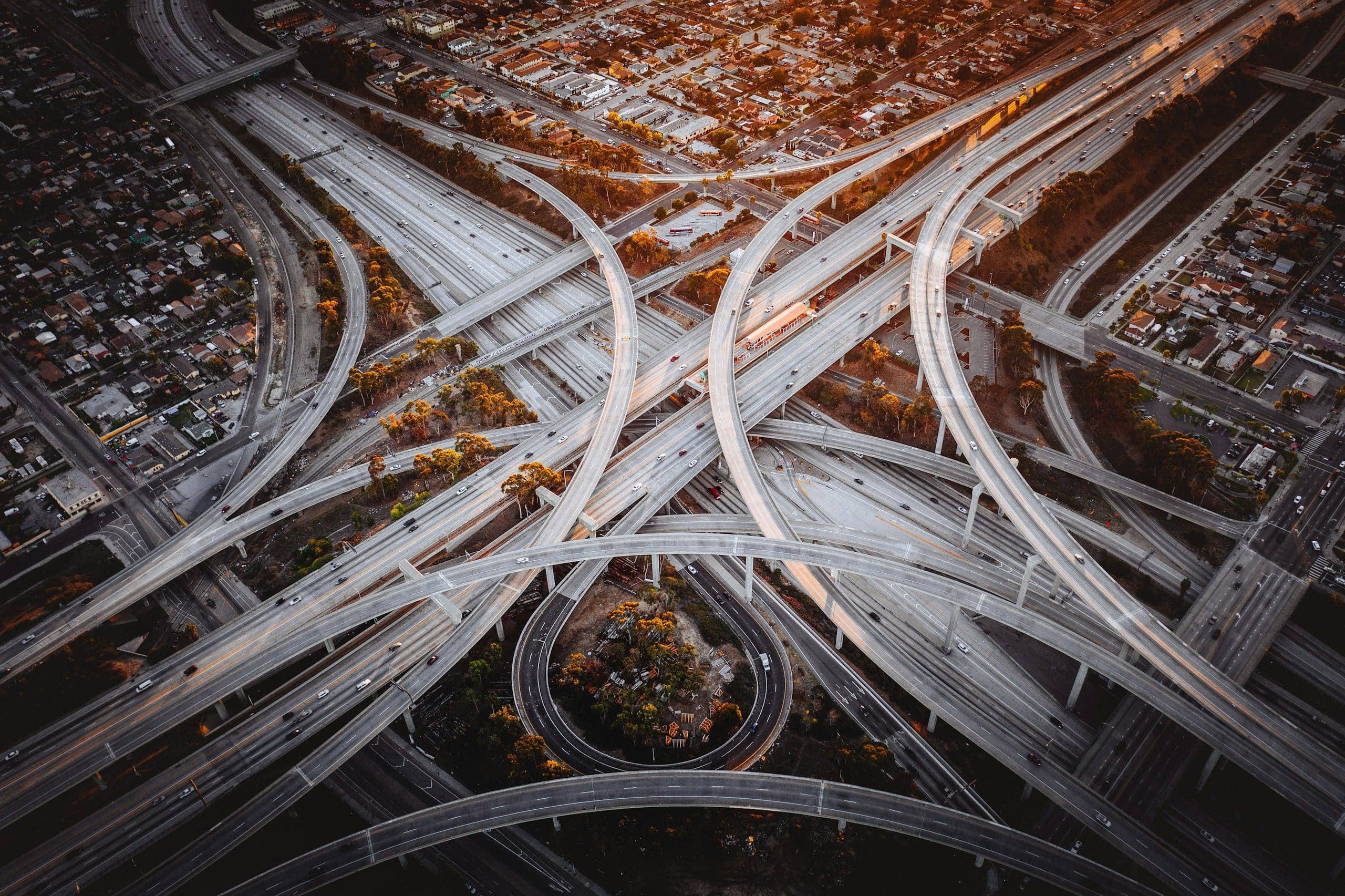 Luftaufnahme eines mehrstöckigen Autobahnkreuzes in Los Angeles im warmen Abendlicht